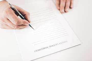 Attorney signing a patent license agreement